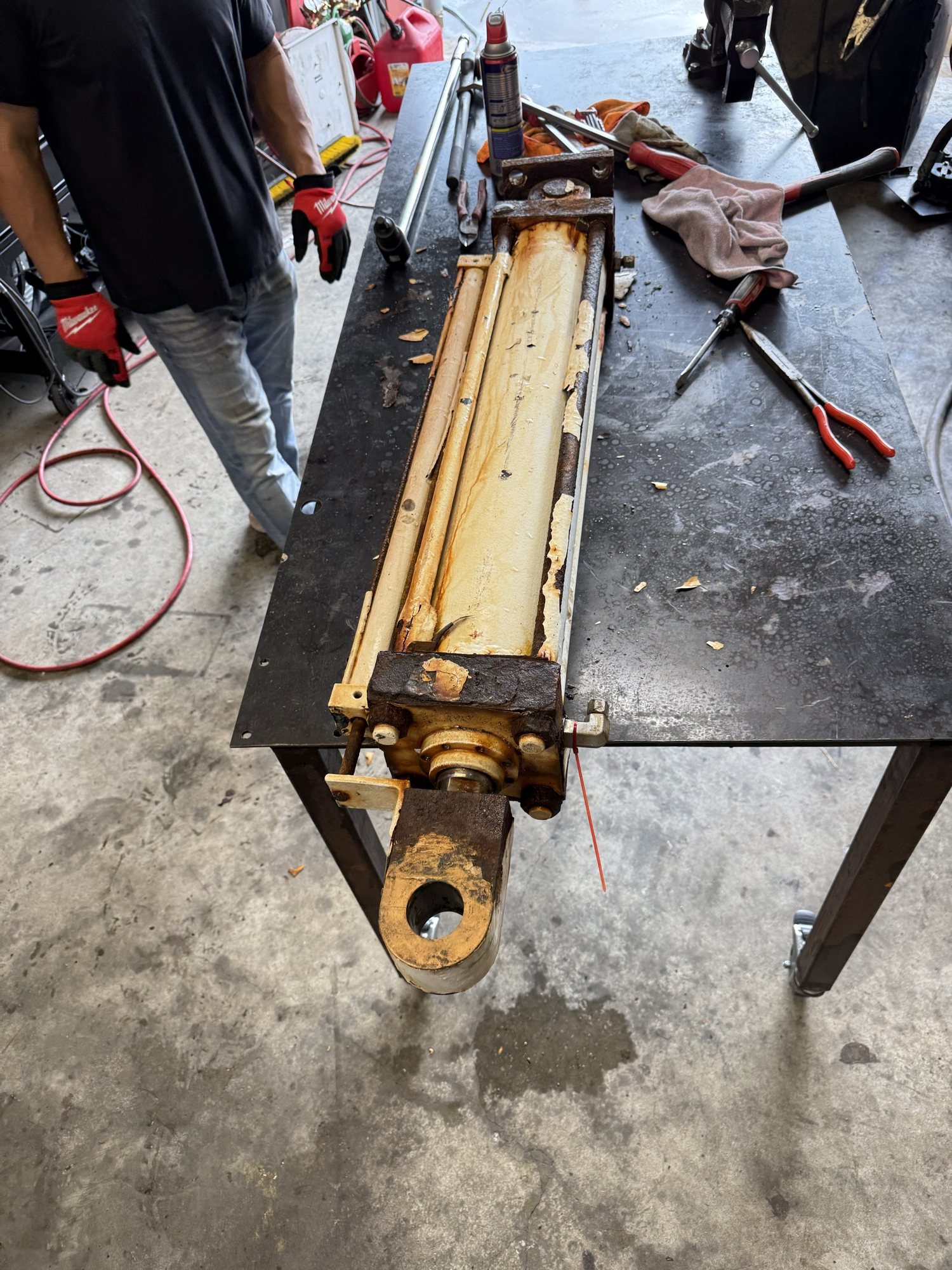 Yellow heavy equipment hydraulic cylinder removed for service